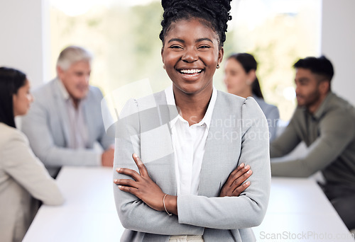 Image of Portrait, smile and a business black woman arms crossed in the boardroom with her team in the background. Leadership, workshop and confidence with a happy young female employee standing in the office