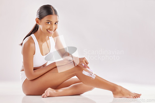 Image of Woman in portrait, shave legs for hair removal and beauty with skincare, foam product and razor on studio background. Epilation, happy female model with shaving cream for grooming and hygiene