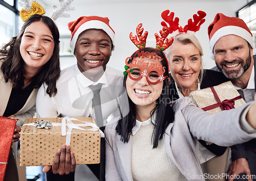 Image of Friends, selfie and business people at christmas party in the office with silly accessories. Diversity, smile and happy corporate colleagues taking picture together with gifts at festive celebration.