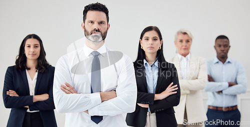 Image of Portrait, leadership and a business man arms crossed with his team in their professional office. Management, collaboration or teamwork with a male boss and colleagues looking confident together