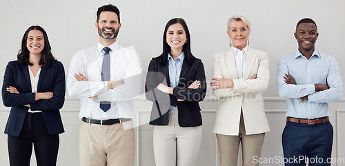 Image of Portrait, collaboration and arms crossed with a diverse leadership team standing in their professional office. Business, teamwork and management with a group of colleagues looking confident at work