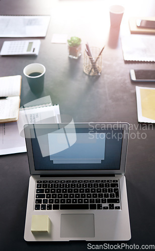 Image of Laptop, presentation and planning with a table in an empty boardroom ready for a strategy meeting. Computer, flare and still life with technology in a professional office for finance or accounting