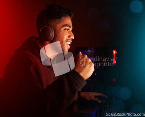 Image of Man in dark room, video game and winning with fist pump, online streaming with gaming competition and esports. Neon lighting, cyber and male streamer celebrate win with gamer tournament and success