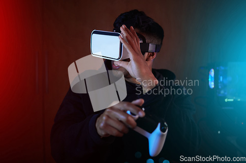 Image of Man in dark room, video game with VR goggles and controller, online streaming with gaming and metaverse. Digital world, male streamer and future technology with games and virtual reality experience