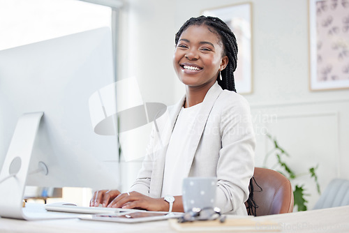 Image of Happy, portrait of businesswoman typing and computer at her desk in a modern workplace office. Online communication, networking and African female accountant writing an email on pc at her workstation