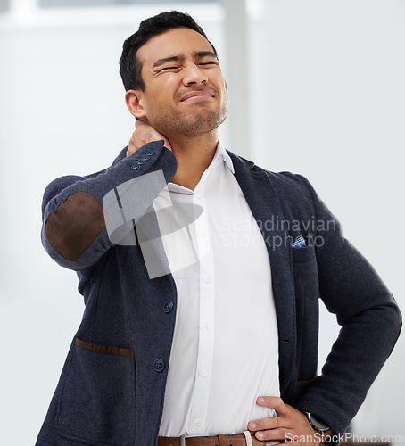 Image of Accident, neck pain and injury with a business man standing hand on hip in his office while working. Medical, healthcare and anatomy with a male employee holding his stiff shoulder in the workplace