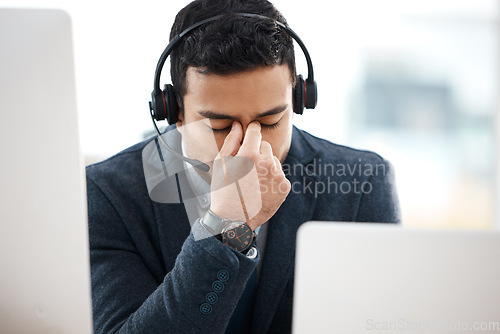 Image of Headache, call center and business man with fatigue, stress and anxiety in a office with deadline. Contact us, telemarketing and phone consultation work of a worker with eye strain feeling tired