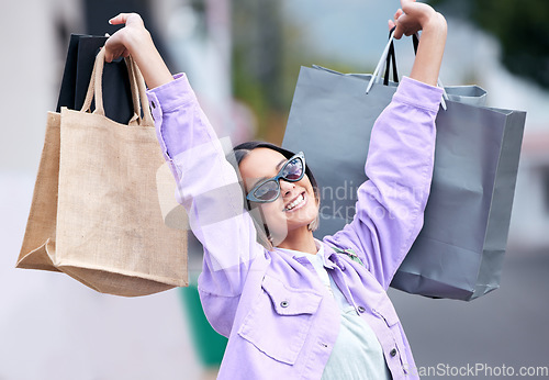 Image of Bags, shopping and happy woman in the city for fashion, retail and brands of clothes on sale, discount or promotion. Smile, girl and shopper with luxury, boutique or designer products from store