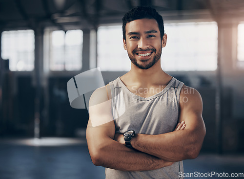 Image of Fitness, smile and portrait of a personal trainer with crossed arms in the gym before a strength workout. Confidence, happy and male athlete after a bodybuilding arm exercise in a sports center.