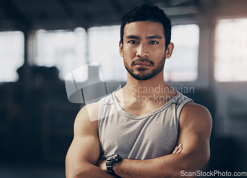 Image of Fitness, crossed arms and portrait of a personal trainer in the gym before a workout consultation. Confidence, serious and male athlete with a strength arm exercise for biceps in a sports center.