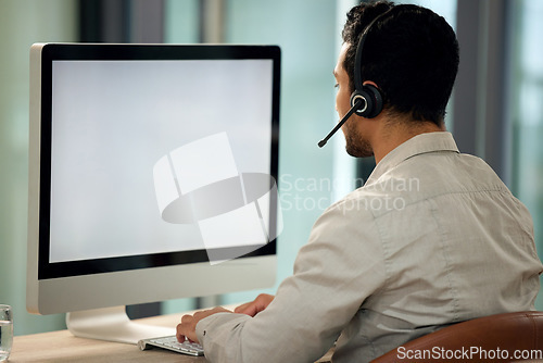 Image of Call center, man and back with computer, typing and blank screen for copy space, telemarketing and mockup. Young male consultant, pc and customer service with advice, email or communication in office