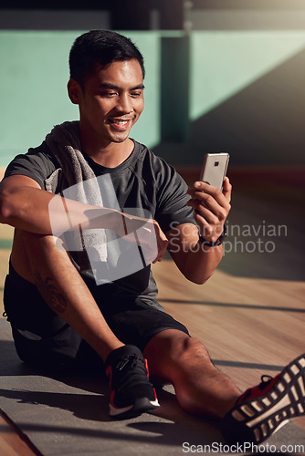 Image of Gym, phone and happy man on floor on video call, fitness and happiness with media, exercise and chat. Internet, cellphone and workout, healthy male athlete on mat in pilates or yoga studio with smile