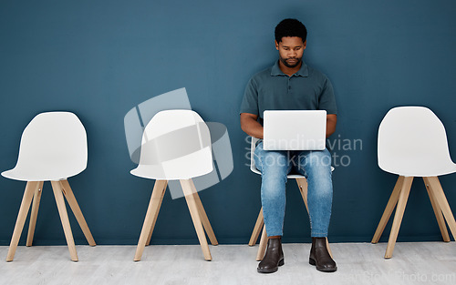 Image of Waiting room, laptop and black man for career opportunity, creative job search and application to human resources. Young male person in queue with computer for online research, recruitment or website