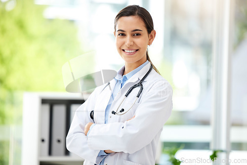 Image of Portrait, medicine and arms crossed with a doctor woman in the hospital for insurance or treatment. Healthcare, happy or smile with a young female medical professional standing alone in a clinic