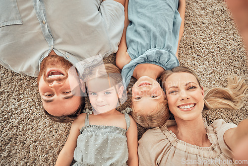 Image of Top view, selfie and portrait of parents and children on living room floor for bonding, quality time and relax. Happy family, smile and mom and dad with girls for care, love and take picture at home