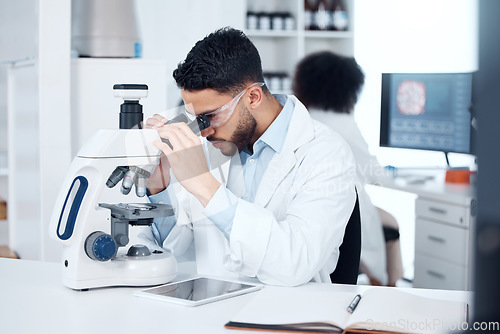 Image of Science, microscope and male scientist analyzing with biotechnology in a medical laboratory. Particles, pharmaceutical and man researcher working on scientific project for healthcare innovation.