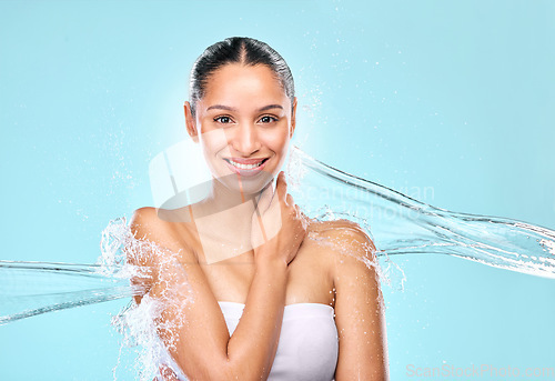 Image of Water, splash and skincare with portrait of woman in studio for hygiene, beauty and shower. Wellness, cleaning and fresh with female model on blue background for spa, cosmetics and mockup space