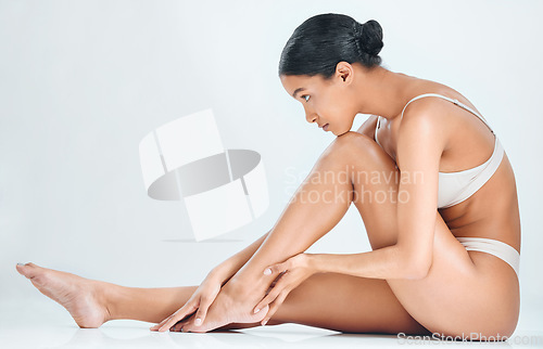 Image of Woman profile, smooth skin and legs epilation of wellness, cosmetic wax and skincare treatment in studio. White background, female model and natural beauty with body care and leg shave in underwear