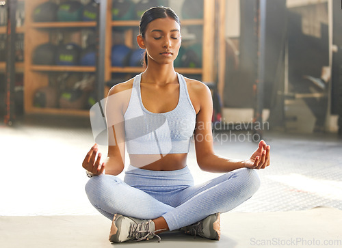 Image of Yoga, meditation and Indian woman for wellness, mindfulness and breathing exercise on gym floor. Mental health, meditate and female person in lotus pose for calm mindset, zen and balance in training