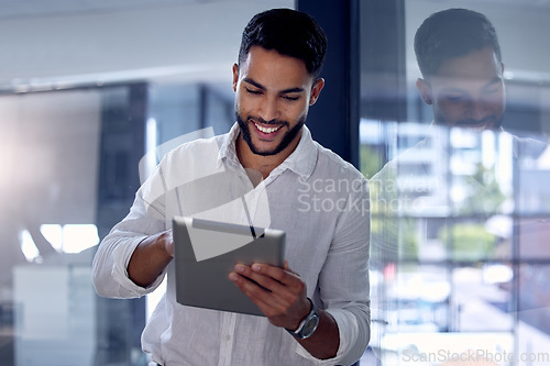 Image of Tablet, night and research with a business man, happy while working alone in his office after hours. Technology, internet and smile with a male employee doing an online search for information or data