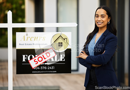 Image of Sold board, realtor woman and portrait with arms crossed for home investment, property sale and agency success. Happy face of real estate agent, landlord or biracial person, new house poster or sign