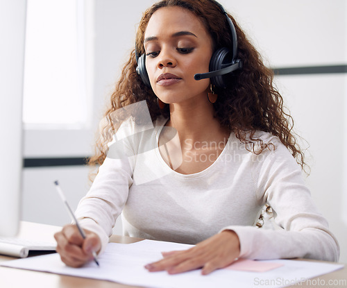 Image of Call center, serious woman and writing notes for support, customer service and CRM consulting in office. Focused female agent, consultant and documents for telemarketing, administration and web sales