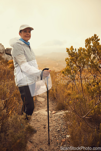 Image of Trekking pole, hiking and travel with portrait of old woman in nature for wellness, fitness and retirement. Journey, freedom and senior hiker walking in outdoors for environment, adventure or sunrise
