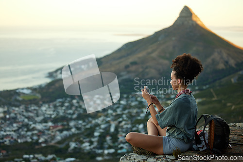 Image of Woman, hiking and phone on mountain for travel in cape town for wellness on the weekend. Female hiker, mobile and adventure on a cliff with cityscape for scenery of lions head in the outdoor.