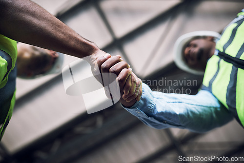 Image of People, architect and handshake in construction, hiring or building in teamwork partnership on site. Low angle of contractor or engineer shaking hands in recruiting, architecture agreement or deal