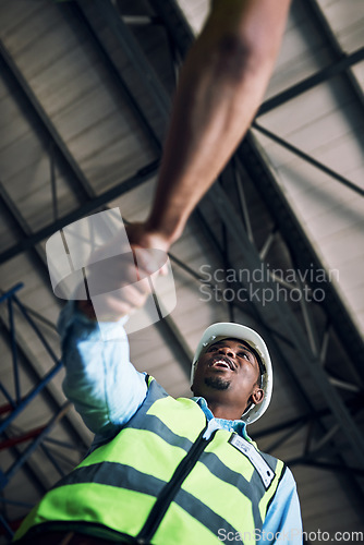 Image of Black man, architect and handshake for construction, building or hiring in teamwork partnership on site. Low angle of African male engineer shaking hands in recruiting, architecture agreement or deal