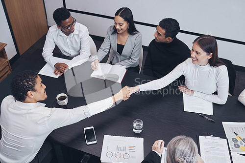 Image of Business people, handshake and teamwork in meeting for partnership, corporate growth or deal above at the office. Happy employees shaking hands for b2b, agreement or introduction at the workplace