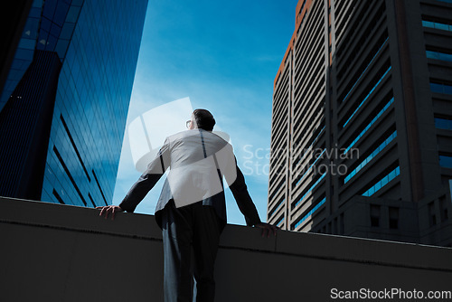 Image of Business, man and thinking at city on rooftop about career or future with goal in company. Professional, person and skyscraper on roof is standing with vision or hope for decision as leader at work.