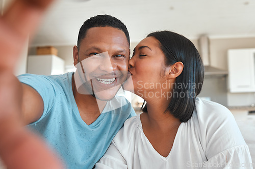 Image of Young couple, kitchen and selfie with kiss, happiness or love with smile in post, social media app and home together. Man, woman and happy with photography, profile picture and internet blog in house
