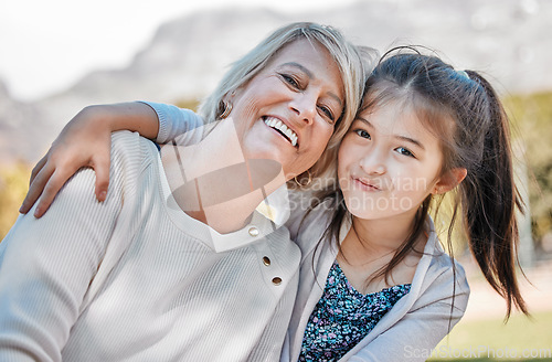 Image of Grandmother, girl and portrait with happiness outdoor and hug for happy family at the park. Female child, woman and face of grandma with love, joy and smile in garden with kids, care or bond together