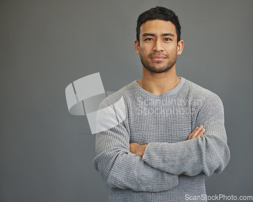 Image of Portrait of man in studio with mockup space, arms crossed and confident smile on studio backdrop in casual fashion. Relax, confidence and face of male on grey background with focus, pride and mock up
