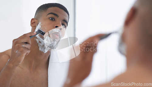 Image of Man is shaving with cream, mirror and beauty, hair removal for hygiene and grooming during morning routine at home. Male person in bathroom, razor to shave and foam with fresh and clean skincare