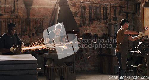Image of Hammer, anvil and sparks with a men working in a foundry for metal work manufacturing or production. Industry, welding and trade with a blacksmith people in a workshop, plant or industrial forge