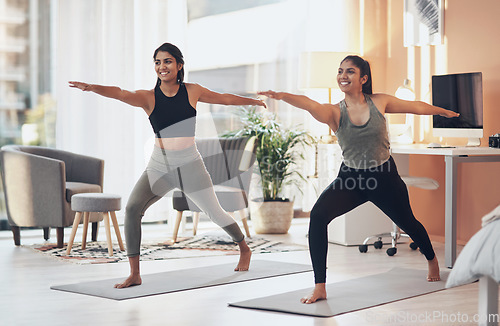 Image of Friends, yoga and women exercise together in a house for health, balance or wellness. Happy Indian sisters or female family in a home for stretching workout, warrior pose and fitness with a partner