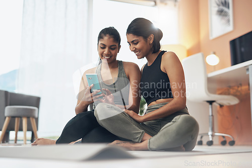 Image of Exercise, phone and women together on home floor with internet for social media app. Indian sisters or female friends in lounge with smartphone for online class, chat or fitness workout with partner