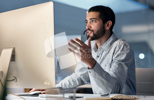 Image of Call center, man and talking at computer for customer service, telemarketing sales and CRM consulting at night. Male agent, desktop pc and communication for advice, questions and technical support