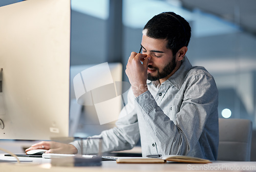 Image of Call center, man and headache at computer for stress, burnout and problem with client communication at night. Tired telemarketing consultant at desktop with crisis , frustrated and bad sales service