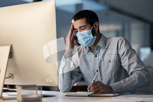 Image of Call center, man and headache with face mask at computer for stress, burnout or problem with client communication. Tired telemarketing consultant with virus protection for crisis, bad service or pain