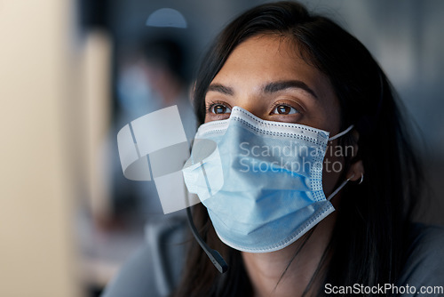 Image of Call center, woman and face mask at computer for customer service, technical support and CRM consulting in office. Female telemarketing agent with virus protection for online help, questions or sales