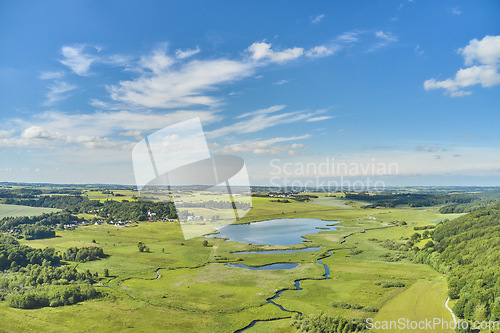 Image of Nature, lake and environment with drone of countryside for agriculture, farming and summer. Grass, travel and landscape with aerial view of meadow field and blue sky for growth, plants and ecology