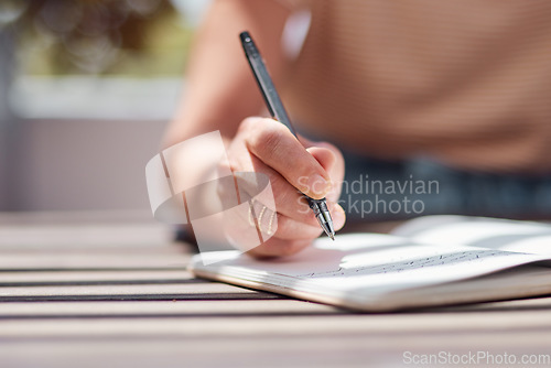 Image of Hand, journal and book with a woman writer sitting outdoor in summer for inspiration as an author. Idea, planning and notebook with a female person using a pen to write in a planner or diary outside