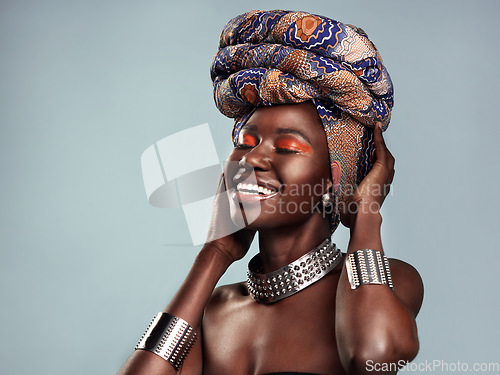 Image of Beauty, black woman and smile with African head scarf and mockup in a studio. Isolated, blue background traditional Africa turban with a young female model with culture and pride with cosmetics
