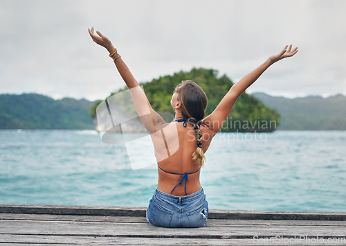 Image of Woman, open arms and ocean pier holiday with happiness and freedom on Thailand vacation. Female person, back and tropical island with a wood deck by the sea and beach in summer travel by blue water