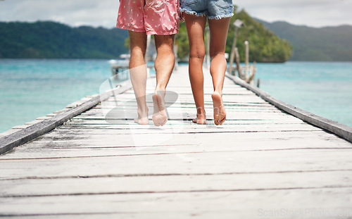 Image of Couple, feet and ocean pier on a island on vacation with walking freedom by sea. Travel, tropical beach and deck walk of a man back and woman together with love in summer on a holiday outdoor in sun