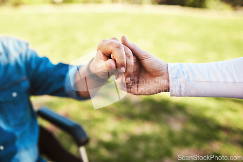 Image of Senior, caregiver and holding hands on wheelchair in support, love or healthcare for life insurance in nature. Hand of nurse helping male patient or person with a disability at nursing home outdoors