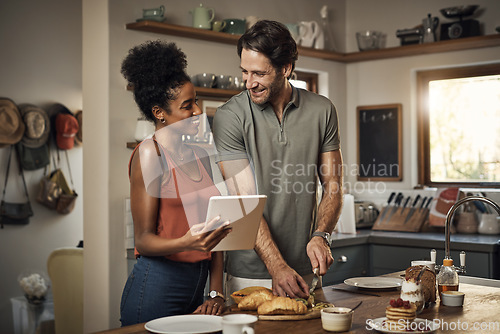 Image of Interracial couple, tablet and cooking in kitchen for recipe, social media or online food vlog at home. Man and woman preparing breakfast meal or cutting ingredients together with technology on table